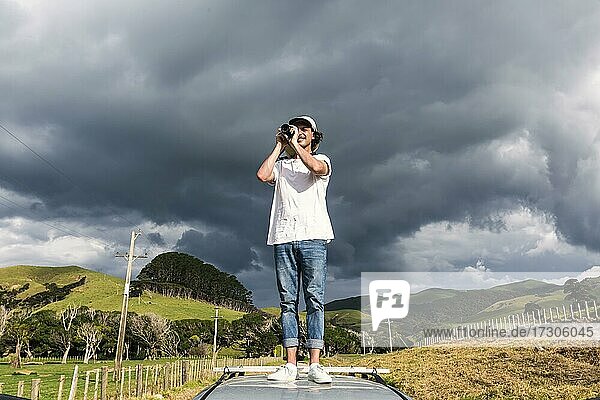 Typ auf dem Autodach beim Fotografieren  Fletcher Bay  Coromandel  Nordinsel  Neuseeland  Ozeanien