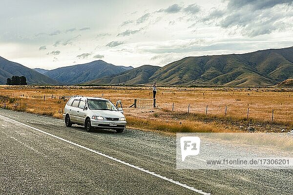 Kerl mit Kamera neben dem Auto  Omarama  Waitaki District  Canterbury  Südinsel  Neuseeland  Ozeanien