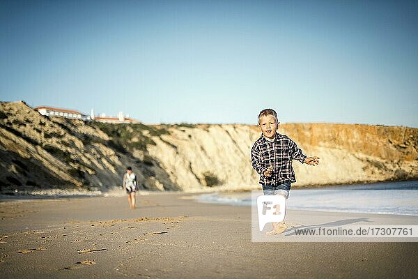 Der kleine Junge läuft fröhlich am Strand bei Sonnenuntergang  Algarve  Portugal  Europa