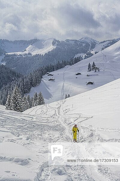 Skitourengeher  Junge Mann auf Skitour zum Taubenstein  verschneite Berge und Hütten  Mangfallgebirge  Bayerische Voralpen  Oberbayern  Bayern  Deutschland  Europa
