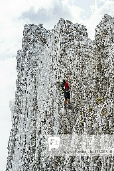 Young man climbing a vertical rock face without a rope  rocky mountains and scree  near Hochkalter  Berchtesgadener Alpen  Berchtesgadener Land  Upper Bavaria  Bavaria  Germany  Europe