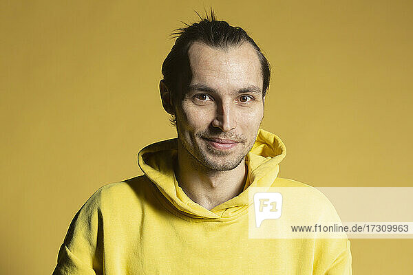 Porträt lächelnder Mann in gelbem Kapuzenpulli