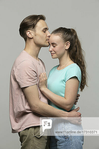 Studio Porträt liebevoll  zart junges Paar umarmt