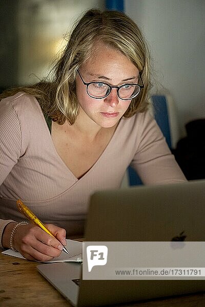 Young woman sits in front of laptop and works