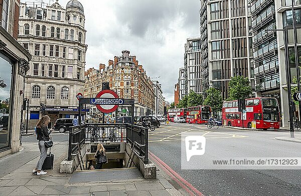 Eingang zu einer Ubahnstation  Schild Underground  Straße mit roten Bussen  London  England  Großbritannien  Europa