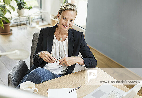 Geschäftsfrau lächelnd beim Sitzen im Büro