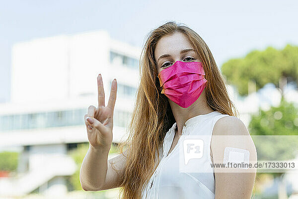 Geschäftsfrau mit Gesichtsschutzmaske gestikuliert während COVID-19