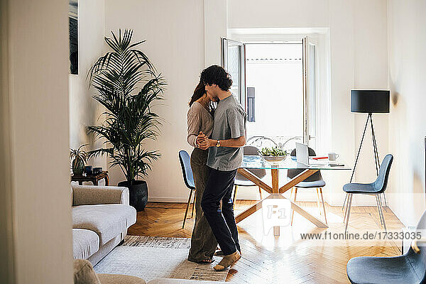 Couple doing romance while standing in living room
