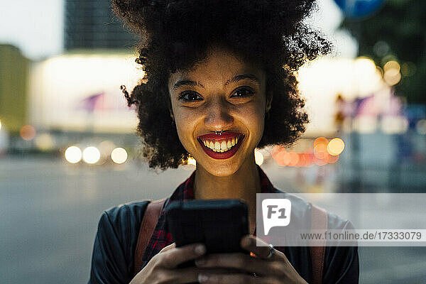 Lächelnde Frau mit Smartphone in der Hand