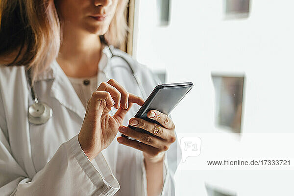 Eine Ärztin benutzt ein Smartphone im Krankenhaus