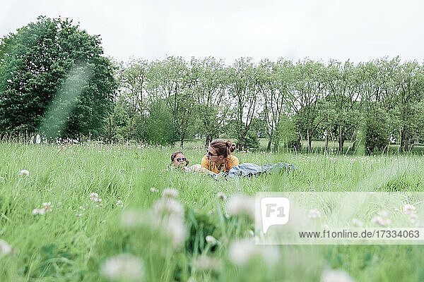 Mutter und Tochter liegen im Gras im Park