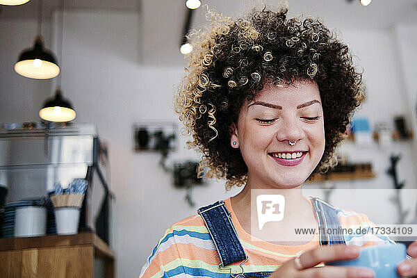 Lächelnde Frau mit Tasse in einem Cafe