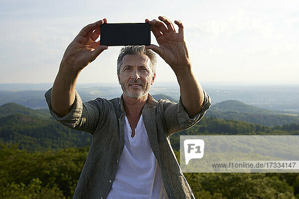 Mann nimmt Selfie durch Smartphone