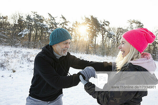 Happy woman playing with man during winter