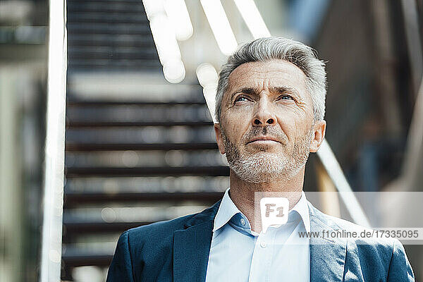 Thoughtful businessman looking away in industry