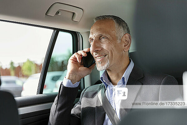 Male professional talking on mobile phone while sitting in car