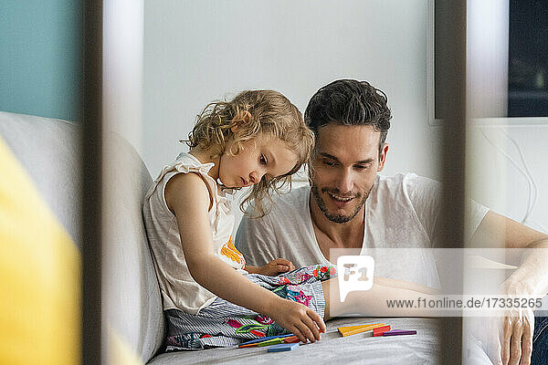 Mädchen ordnet ein Puzzle  während sie mit ihrem Vater zu Hause sitzt