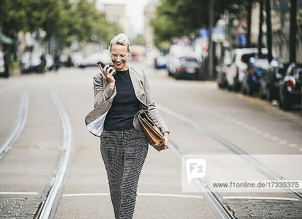 Fröhliche Pendlerin  die in der Straßenbahn mit ihrem Mobiltelefon spricht