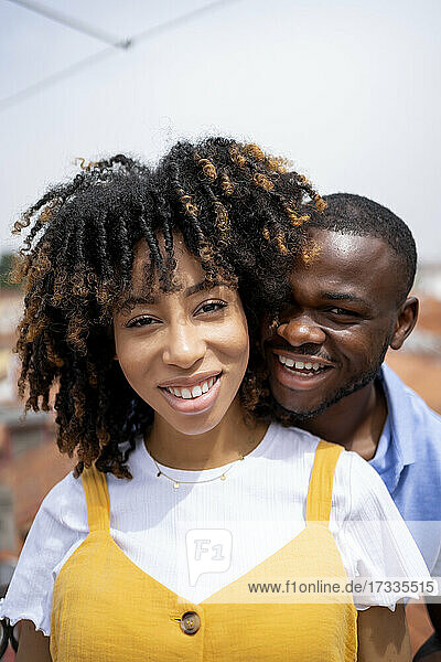 Lächelndes multiethnisches junges Paar an einem sonnigen Tag