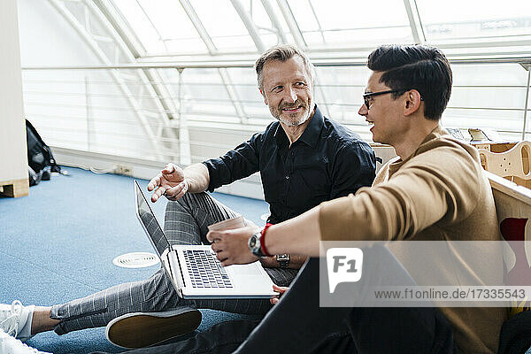 Creative businessman having discussion with colleague in office