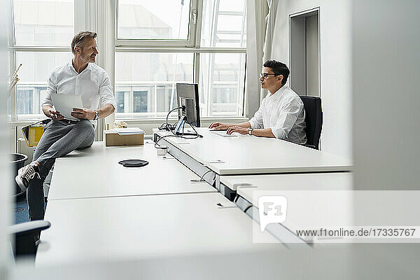 Businessman discussing with colleague while working at office