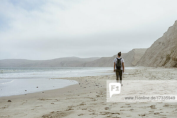 Junger Mann  der am Strand von Point Reyes  Kalifornien  USA  im Sand spazieren geht