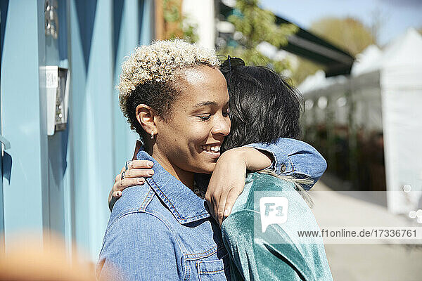 Lesbian couple embracing each other on sunny day