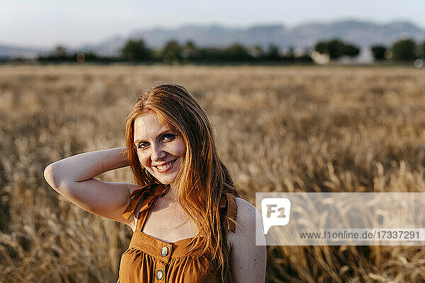 Lächelnde rothaarige Frau auf einem landwirtschaftlichen Feld