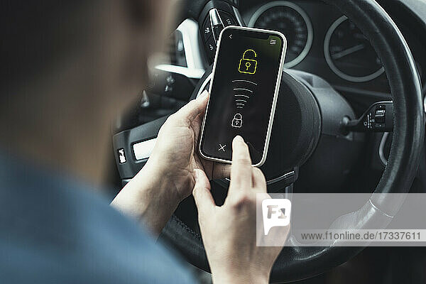 Woman unlocking mobile phone in car