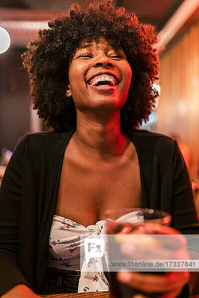 Happy Afro woman at bar