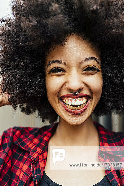 Fröhliche junge Frau mit Afro-Frisur und Nasenring