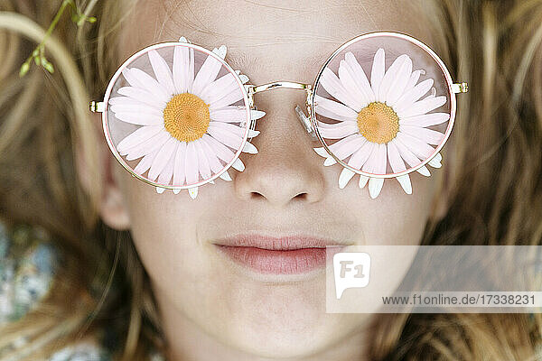 Smiling girl wearing chamomile flower eyeglasses