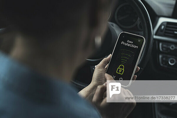 Woman unlocking data protection lock on smart phone in car