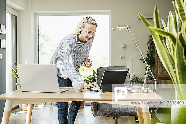 Geschäftsfrau verwendet digitales Tablet im Stehen zu Hause