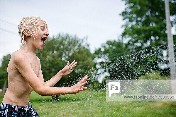 Canada  Ontario  Kingston  Shirtless boy (8-9) playing with water