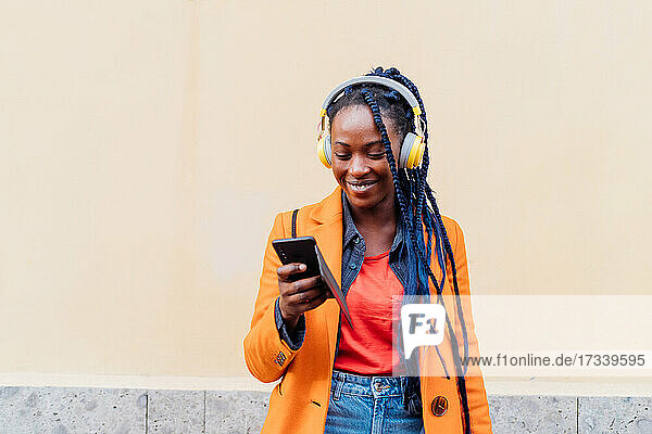 Italien  Mailand  Frau mit Kopfhörer und Smartphone im Freien