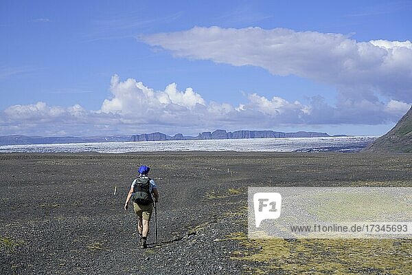 Frau wandert auf auf weiter Schotterfläche ins Morsardalur  Skaftafell NP  Austurland  Island  Europa
