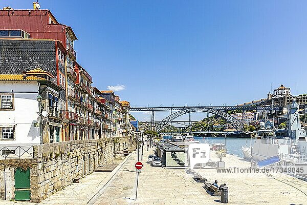 Bunte Häuser an der historischen Uferpromenade und die berühmte Brücke über den Fluss Douro in Porto  Portugal  Europa