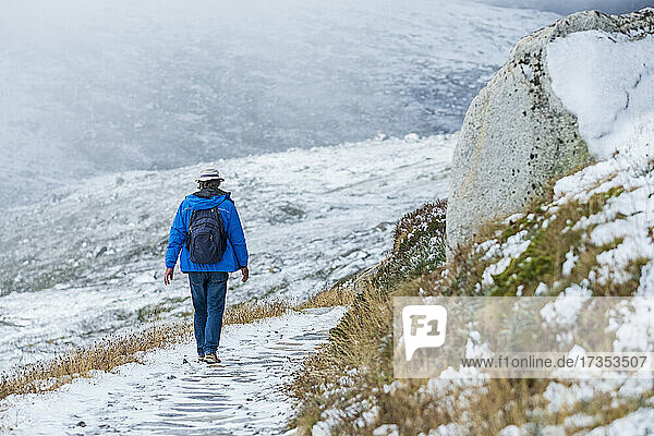 Australia  New South Wales  Woman hiking on snowy trail at Charlotte Pass in Kosciuszko National Park