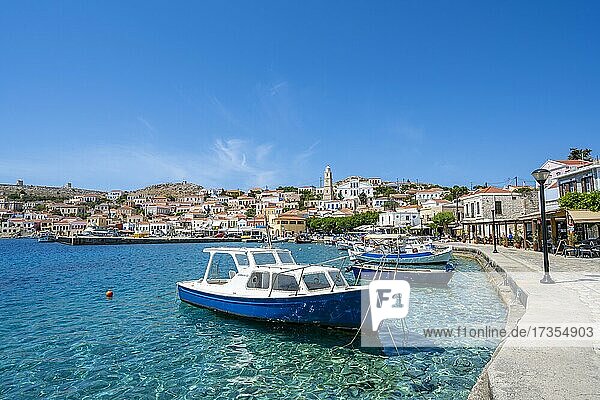 Fischerboote im Hafen von Chalki mit türkisblauem Wasser  Uferpromenade mit bunten Häusern des Ortes Chalki  Chalki  Dodekanes  Griechenland  Europa