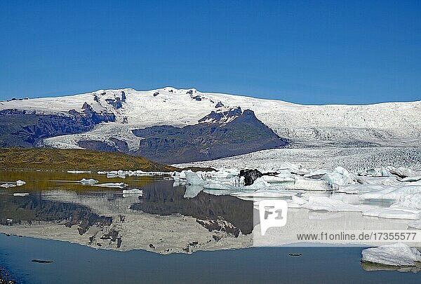 Eisberge und Gletscher spiegeln sich in einem See  Gletscher und Berge im Hintergrund  Fjallsarlon  Vatnajökull Nationalpark  Island  Europa