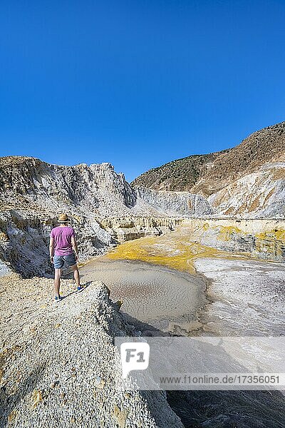Young tourist at a crater  volcano caldera with pumice fields  yellow coloured sulphur stones  Alexandros crater  Nisyros  Dodecanese  Greece  Europe