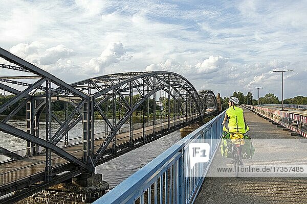 Frau fährt mit dem Fahrrad über Brücke neben der Alten Harbrücker Elbbrücke  Brücke des 17. Juni  Harburg  Hamburg  Deutschland  Europa