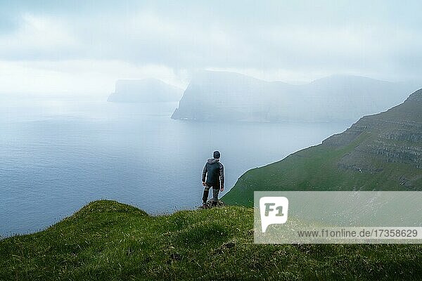 Person steht auf dem Berg und schaut auf den Ort Mikladalur  Kalsoy  Faroer Inseln