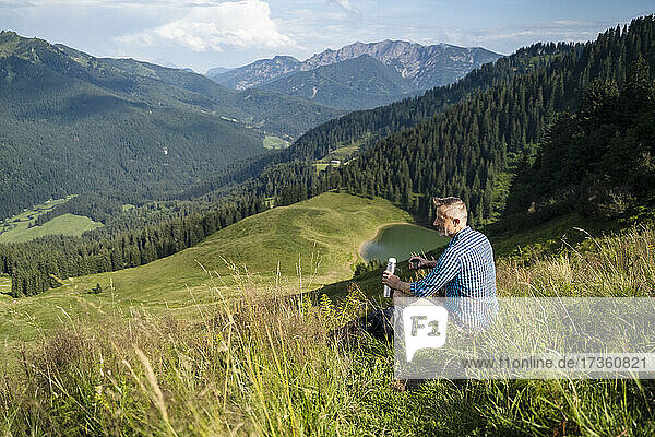 Male hiker looking at mountain during sunny day