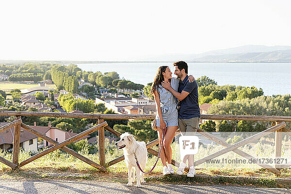 Couple looking at each other while standing with dog