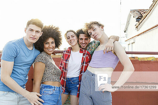 Lächelnde multiethnische Freunde und Freundinnen auf der Terrasse