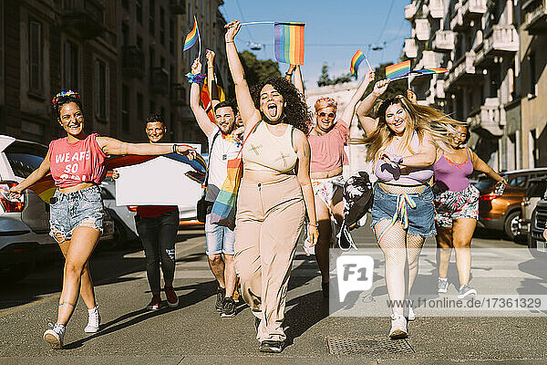 Fröhliche weibliche und männliche Aktivisten  die an einem sonnigen Tag auf der Straße für Gleichberechtigung protestieren