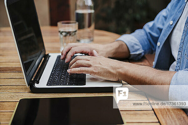 Male freelancer working on laptop at desk