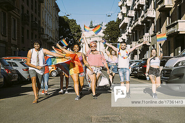 Glückliche männliche und weibliche Aktivisten protestieren an einem sonnigen Tag bei einer Pride-Veranstaltung